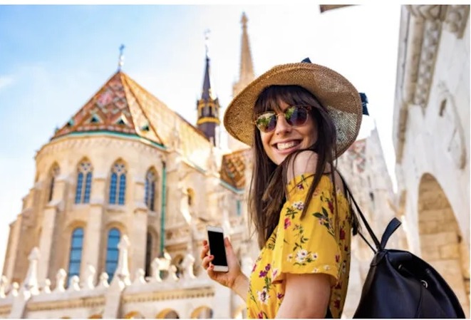 Viajante sorrindo em ponto turistico historico durante uma viagem de lazer